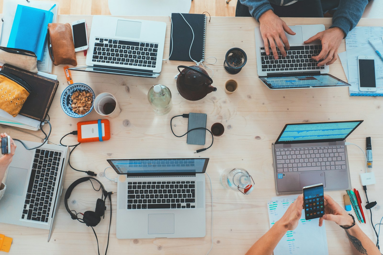SaaS team collaborating on laptops around a table